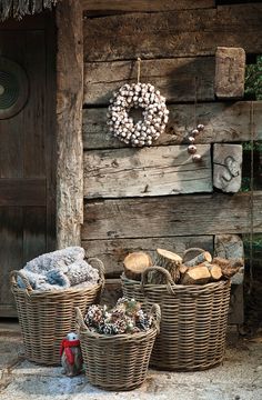 three wicker baskets filled with food next to a wooden wall and wreath hanging on the wall