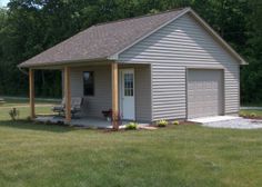 a small house with a covered porch in the grass