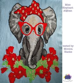 an elephant with glasses and a red bow on it's head is sitting next to some flowers