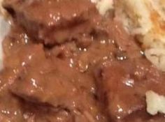 a close up of a plate of food with meat and gravy on it