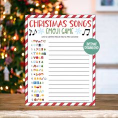 a christmas song emoj game on a table with a christmas tree in the background