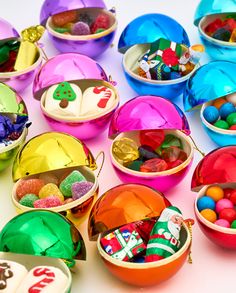 many colorful bowls filled with candy and candies on a white table top in front of each other