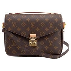 This bag is made of classic Louis Vuitton monogram toile canvas. The bag features a vachetta cowhide leather top handle, an optional, adjustable Monogram canvas shoulder strap, and a rear zipper pocket. The envelope-style crossover flap opens with a polished brass S-lock to a partitioned brown microfiber interior. Color: Brown Material: Coated canvas Year: 2022 (No date code) Measures: H 7.5” x L 10” x D 3” Drop: 1”& 18” (shoulder strap) Comes with: Dust bag and shoulder strap Condition: Like new. Faint marks to vachetta. Faint hairline scratches to hardware. Made in France Pochette Metis, Interior Color, Monogram Canvas, Leather Top, Polished Brass, Fashion Handbags, Cowhide Leather, Louis Vuitton Monogram, Top Handle