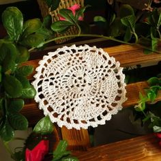 a white doily sitting on top of a wooden bench