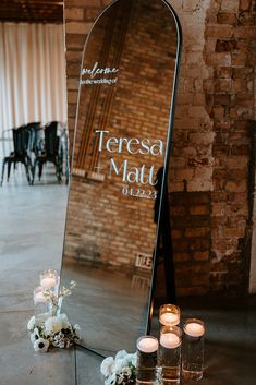 a large mirror sitting on top of a table next to candles