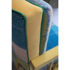 a close up of a chair with blue and yellow fabric on it's back