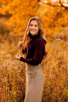 a beautiful young woman standing in tall grass