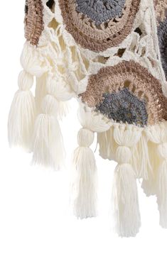 a crocheted blanket with tassels hanging from it