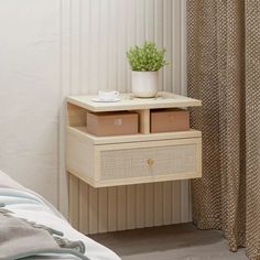 a small table with two drawers and a potted plant on top