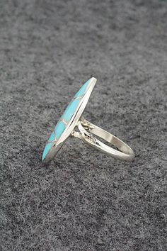 This turquoise and sterling silver inlay ring was made by Zuni silversmith Orena Leekya. The back is signed O. Leekya and Zuni.Size: 7.5Length: 1"Width: 1/2"Free shipping on all orders! We ship with USPS and always include tracking. All orders ship within a day of payment.Returns are accepted up to 30 days after you receive your order. Just send us a message. Our shop offers cash back or store credit. The item must be returned in new condition. Silver Turquoise Ring With Inlay, Blue Turquoise Ring With Inlay, Oval Turquoise Ring With Sterling Silver Inlay, Turquoise Inlay Round Rings, Unique Silver Turquoise Ring With Inlay, Oval Turquoise Inlay Rings, Oval Turquoise Rings With Inlay, Silver Turquoise Inlay Ring For Gift, Adjustable Oval Turquoise Ring With Inlay