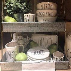 a shelf filled with dishes and cups sitting on top of each other next to a potted plant