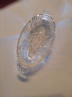 a clear glass bowl sitting on top of a white tablecloth covered table with a white cloth