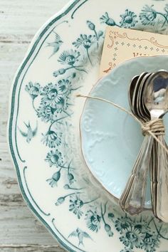 a plate with a fork, knife and napkin tied up to it on a wooden table