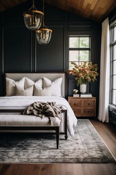 a bedroom with black walls and white bedding in the center is an elegant chandelier