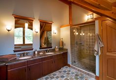 a bathroom with two sinks and a walk in shower