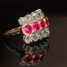 This show stopping Victorian Ring contrasts bright and sparkling Old cut diamonds with lively rich red rubies. Made in England c. 1890. The ring showcases twelve Old European cut diamonds with a total weight of 4 carats. 5 round faceted rubies with a total weight of 3.05 carats. All measurements have been done in the mount and are approximate. Eight Old European cut diamonds measure 4.5 x 2.8 mm = .4 carats each. 4 measure 3.5 x 2.4 mm = .2 carats each. Five rubies measure 5 x 3.4 mm = .61 carat Luxury Red Diamond Ring With Single Cut Diamonds, Antique Ruby Ring With Single Cut Diamonds, Luxury Red Rings With Rose Cut Diamonds, Luxury Red Rose Cut Diamond Rings, Antique Ruby Rings With Single Cut Diamonds, Antique Red Diamond Ring With Rose Cut Diamonds, Victorian Ruby Jewelry With Single Cut Diamonds, Red Victorian Diamond Ring, Classic Red Ruby Ring With Single Cut Diamonds