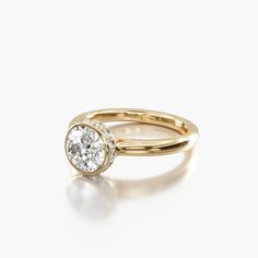 a yellow gold ring with a single diamond in the center, on a white background