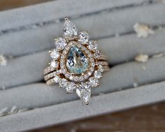 an engagement ring with a blue topaz surrounded by white and brown diamonds in a box