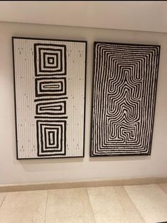 two black and white paintings hanging on the wall