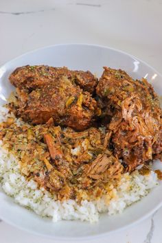 a white plate topped with rice and meat