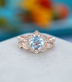 an engagement ring with a blue topazte surrounded by white diamonds on a rock