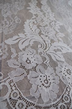 an old lace tablecloth with white flowers on it