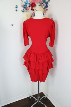 Bold red tiered ruffle dress from the 80s. Features gathered ruffled shoulders and partially open low V back. Please view more details below. Label - Crème  Made in Canada 55% acetate, 45% rayonne Unlined. No stretch to fabric. Should fit a size small or medium but please review measurements below as I am unable to offer returns. Shoulder seam to shoulder seam - 17"  Arms - 13" Chest - 36"  Waist - 28" Hips - 40" Length - 37"  Back nylon zipper closure.  Excellent vintage condition. All vintage 80s Red Dress, Retro Pink Ruffled Dresses, Retro Red Ruffled Dress, Vintage Red Ruffled Skirt, 1970s Vintage Dress With Ruffles, Vintage Hawaiian Dress, Vintage Red Dress, Vintage Dress 80s, Tiered Ruffle Dress