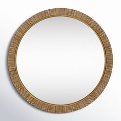 a round mirror on the wall with a wooden frame and gold trimmings,