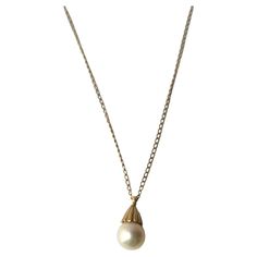 A very beautiful white cultured pearl on a 14-karat yellow gold necklace, circa mid-20th century. Pearl is very beautiful with a high luster. Pearl has a 14-karat yellow gold crown-like design at top attached to 14-karat yellow gold necklace. A beautiful piece to wear alone or stack with other necklaces (as demonstrated.) Very good condition as shown in images. No issues. Dimensions: pearl pendant is .50" long x .25" width. Necklace, from end to end, measures 19.25" long. For gold choker necklace shown, search 1stDibs ref. #: LU4068223052022 For Italian heart necklace search ref. #: LU4068222740332 Vintage Pendant Necklace, Pearl Necklace Vintage, Turquoise Pendant Necklace, Solitaire Pendant Necklace, Yellow Gold Necklace, Cultured Pearl Necklace, Coral And Gold, Gold Choker Necklace, Yellow Gold Setting