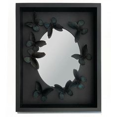 a mirror that has some butterflies on the inside of it and is in a black frame