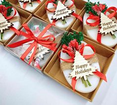 six decorated christmas cookies in a box with red ribbons and bows on them, sitting next to each other