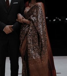 a man in a suit and tie standing next to a woman wearing a shawl