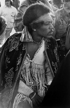 an old black and white photo of a woman in native garb with other people around her