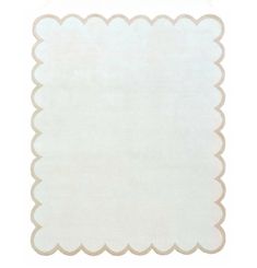 a white rug with scalloped edges on the bottom and an off - white background