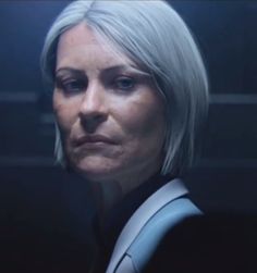 an older woman with grey hair is staring into the distance