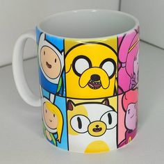 a coffee mug with cartoon characters on it sitting on a white counter top next to a wall