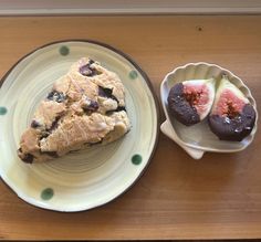 two plates with pastries on them sitting on a wooden table next to each other