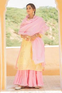 Yellow chanderi kurta with gota jaal detailing on the neckline, sleeves and hemline. Comes with light pink dupatta adorned with gota flowers and ghera sharara in soft mul mul adorned with gota detailing.
Component: 3
Embroidered
Neckline: V Neck
Sleeve Length: Three Quarter
Fabric: Kurta and Dupatta: Chanderi; Pant: Mul Mul
Color: Yellow,Pink
Gota trims
Side slits
Gathered tiers
 - Aza Fashions Yellow Indian Suit, Pant Embroidery, Chicken Suits, Pink Sharara, Kurta And Dupatta, Rain Dance, Yellow Kurta, Chanderi Dupatta, Haldi Outfit