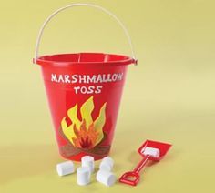 marshmallows in a red bucket next to a shovel on a yellow background