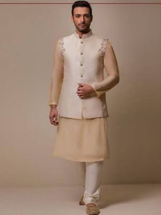 Fitted Cream Nehru Jacket For Eid, Cream Nehru Jacket With Naqshi For Eid, Fitted Off White Nehru Jacket For Eid, Fitted Beige Nehru Jacket With Resham Embroidery, Transitional Cream Nehru Jacket With Naqshi, Transitional Beige Fitted Nehru Jacket, Sleeveless Bandhgala For Wedding And Eid, Festive Fitted Beige Nehru Jacket, Festive Beige Nehru Jacket With Naqshi Detailing