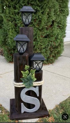 a wooden sign that has some lights on it and a plant in the middle of it