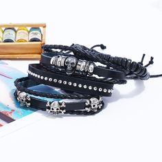 Whether you are into riding, playing your guitar or just hanging out and relaxing, this skull leather bracelet set will go well with any of your outfit. This black bracelet set comes with 4 separate bracelets. You can wear them as a set or individually to create a different look every time. The set consists of metal skulls, beads, leather and studs. Product Information Bracelet set comes with 4 separate bracelets Material: leather/PU leather Chain Type: rope chain Length: adjustable 7 - 8.5 inch Adjustable Gothic Bracelets With Skull Print, Adjustable Black Rock Bracelet, Casual Black Leather Bracelet For Festivals, Adjustable Punk Jewelry With Skull Print, Adjustable Leather Rock Jewelry, Adjustable Leather Rock Style Jewelry, Adjustable Skull Bracelet With Edgy Style, Black Skull Bracelets For Festival, Trendy Black Braided Bracelets For Festival