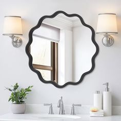 a bathroom sink with a mirror above it and two lights on the wall next to it