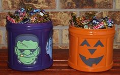 two plastic containers filled with candy sitting on top of a wooden table next to a brick wall