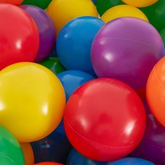 many different colored balloons are piled together