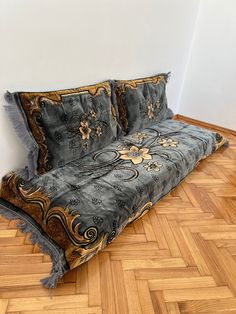 a couch that is sitting on the floor in front of a wall and wooden floors