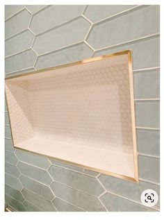 a white bath tub sitting inside of a bathroom next to a tiled shower head and wall