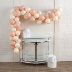 the balloon arch is decorated with pink and white balloons