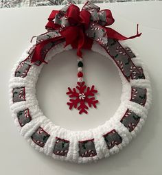 a christmas wreath with a snowflake hanging from it