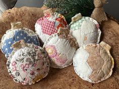 four pieces of fabric sitting on top of a wooden table next to a christmas tree